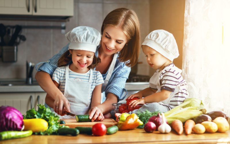 A mom and her two kids are prepping food in the kitchen for supper while following the Dietproof ™ program